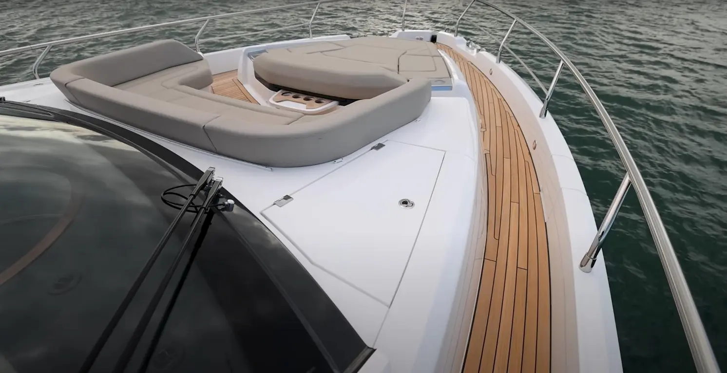 Luxury yacht deck featuring a spacious seating area and wooden flooring overlooking calm waters. Ideal for relaxation.